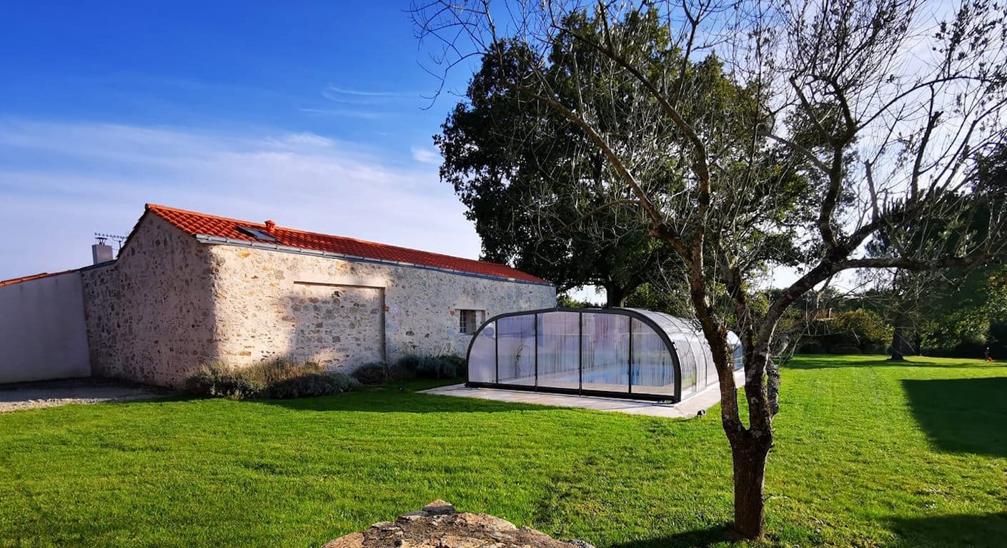 Gîte rural Le Graizeau en Vendée avec piscine couverte, entouré d'un jardin verdoyant et arboré