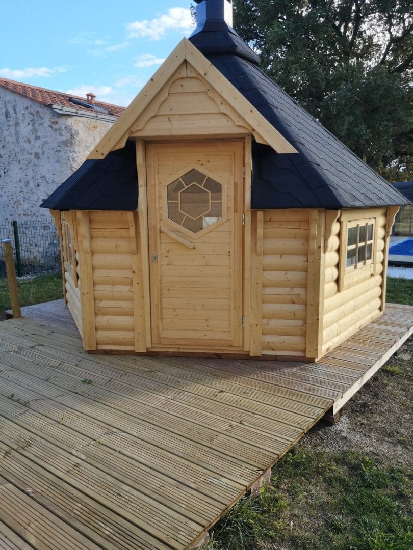 Kota grill : chalet finlandais en bois avec toit noir, équipé d'un grill, parfait pour un repas convivial